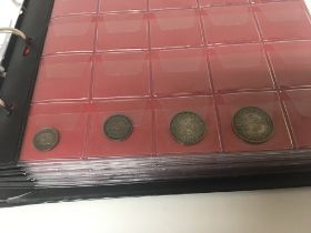 An album containing a collection of coins includin