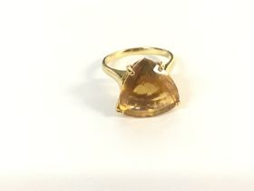 A yellow metal ring set with a large citrine type