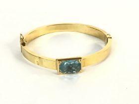 An 18ct gold bangle set with pale blue topaz. 16.6