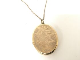 A 9carat gold oval locket with attached 9carat gol