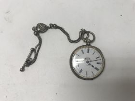A silver ladies pocket watch with an attached hear