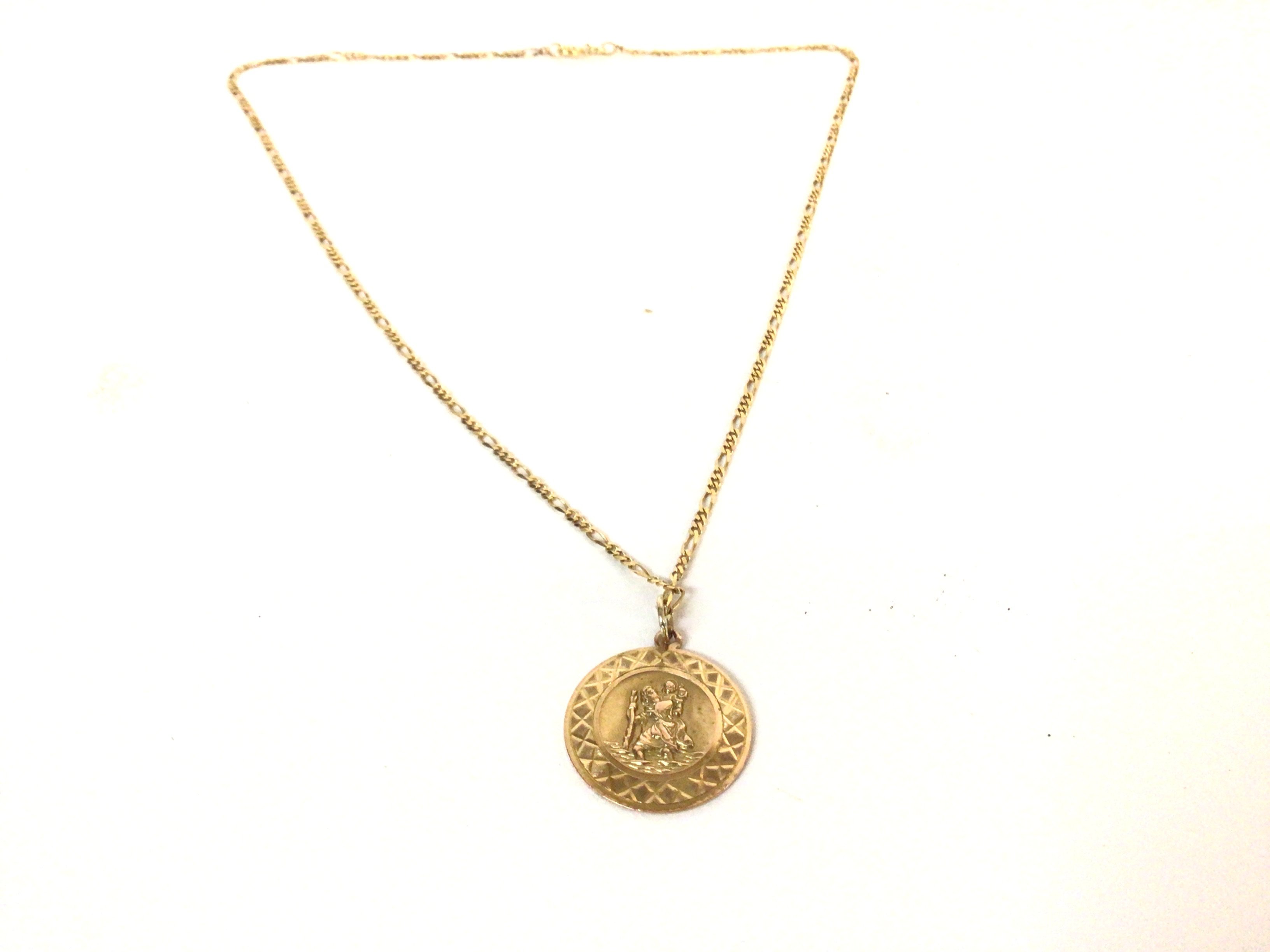 A 9ct gold pendant on a 9ct Figaro chain. Total we