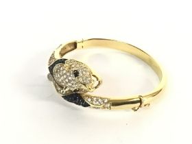 An 18ct gold bangle in the form of a leopard set w