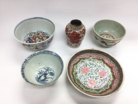 Four Oriental bowls and one small vase, largest di
