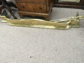 A brass fire kerb and a set of brass fire irons.