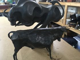 Two bronzed figures in the form of bulls .