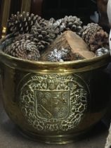 A brass log bin with a coat of arms.
