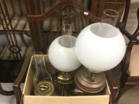 A collection of oil lamps and a pair of wrought ir