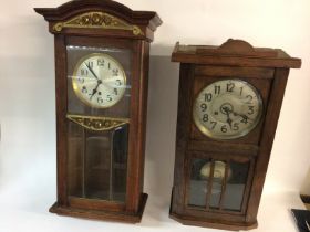 Two oak wall clocks. Postage D Left clock 80x30x17