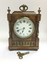 A walnut mantle clock with brass fittings, approx