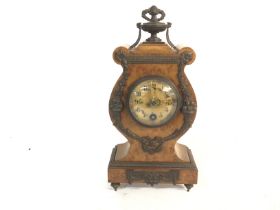 A small maple veneered French clock with key. 27cm