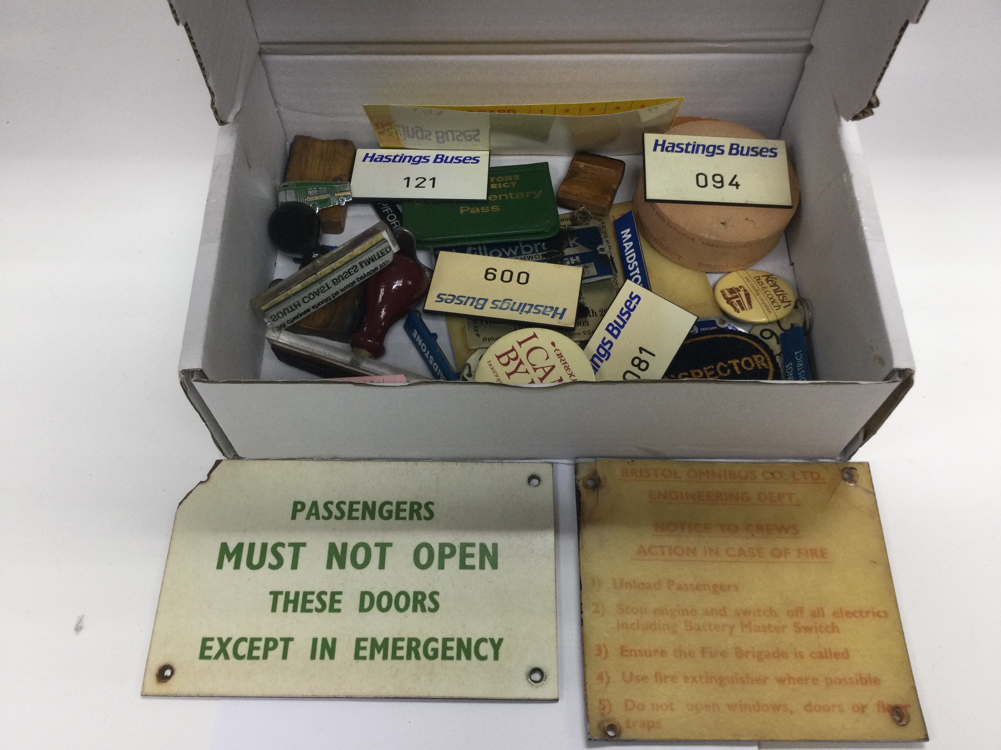 A small box of bus ephemera comprising badges, pla