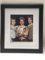 A framed and glazed photo of The Police signed by