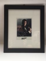 A framed and glazed signed photo of Pierce Brosnan