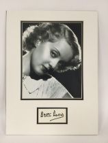 A mounted display of Bette Davis with signature an