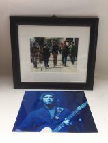 A framed and glazed photo of Oasis signed by Liam