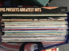 A bag of Elvis Presley LPs, 7inch singles and CDs.