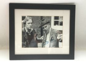 A framed and glazed signed photo of George Cole an