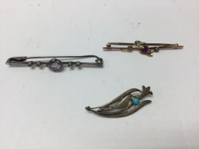 Two silver brooches and one 9ct brooch.