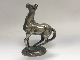 A silver model in the form of a horse in a fitted