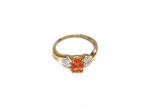 A 9ct gold ring set with central orange stone. Siz