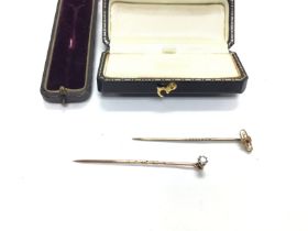 Two Edwardian stick pins. One marked 15ct weighing