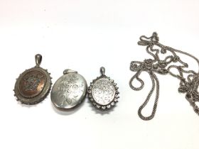 Three silver lockets of various design also a chai