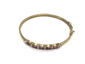 An Edwardian seed pearl and amethyst bangle. 6cm d