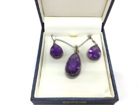 A silver necklace with amethyst pendant and matchi