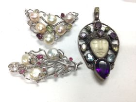 An art nouveau style pendant and other silver broo