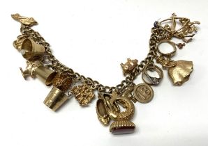 A heavy 9ct gold charm bracelet set with 18 hallma