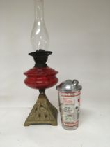 An oil lamp with ruby red glass reservoir and a mi