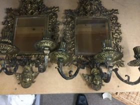 A pair of gilt metal wall mirrors of classical sty