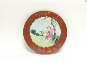 A circular ceramic plaque with hand anted decorati