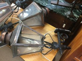 A pair of wrought iron external lamps, approx height one metre. Shipping category D.