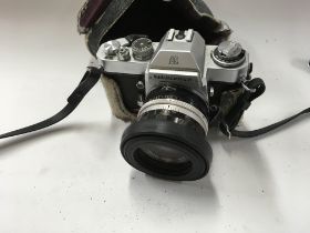 A vintage Nikkormat film camera with case.