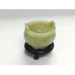 A small jade pot on a carved hardwood stand, total