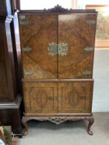 A 1920s burr walnut veneered cocktail cabinet. 160cm x 85cm