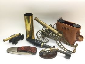 A collection of oddments comprising a brass cannon, a cased pair of binoculars, large folding