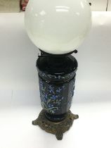 A Victorian oil lamp and shade, the font and base decorated with raised floral decoration.