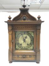 A Victorian wooden gothic styled clock with brass