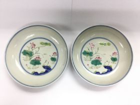 A pair of Oriental dishes decorated with cranes in