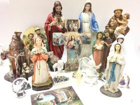 A collection of Christian items including figures of Jesus and The Virgin Mary, Ave Maria necklace