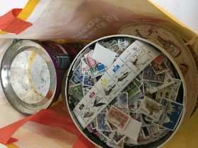 A collection of tins of loose world stamps.