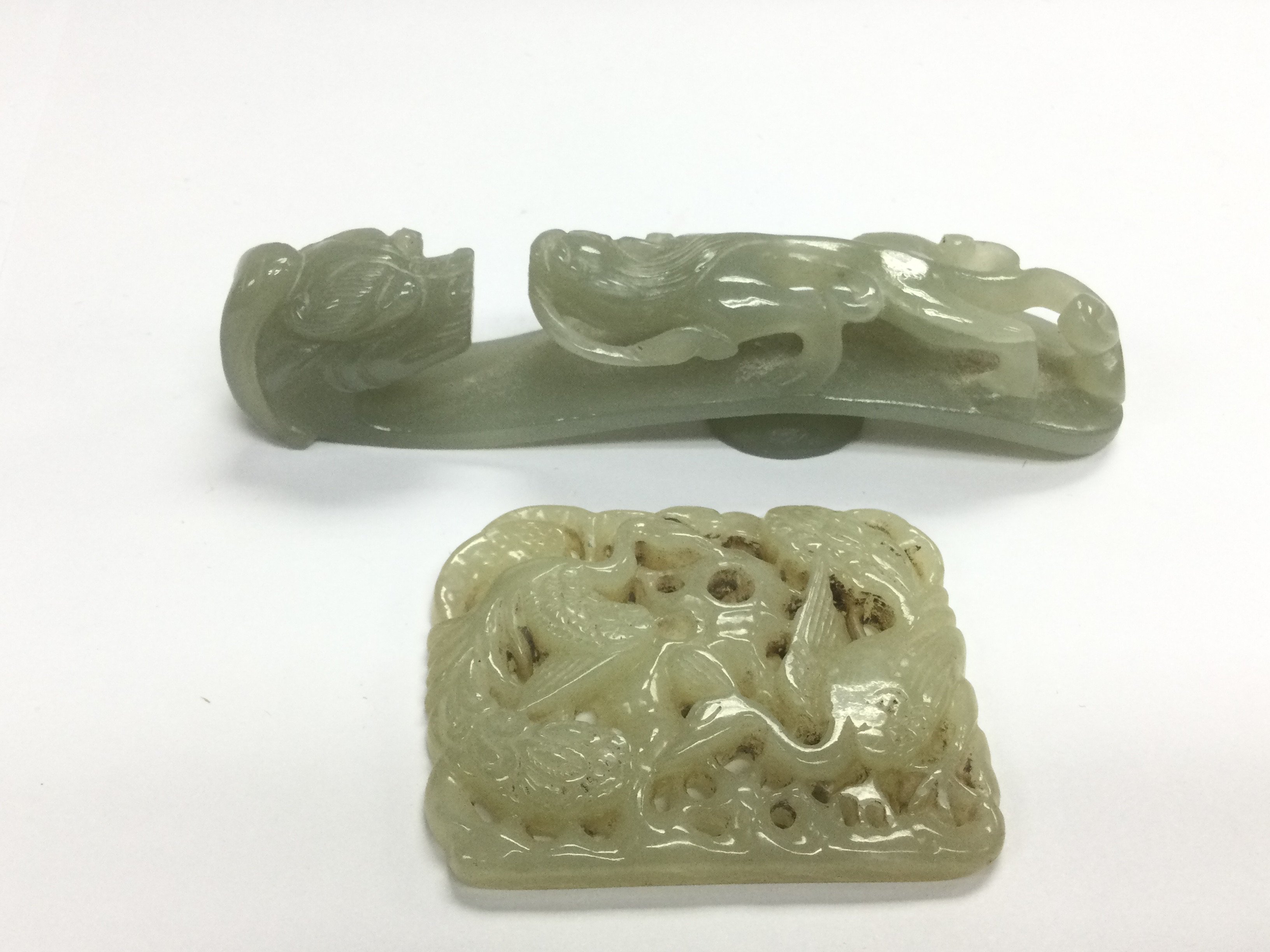 A carved jade belt hook and a buckle (2). Shipping