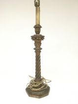 A carved guilt wood candle stick with a stylised spiral twist column. Height 53cm.