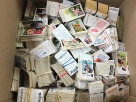 A large box of assorted cigarette cards including