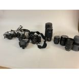 A collective lot of cameras and lenses including a Canon AV-1 camera. Postage C