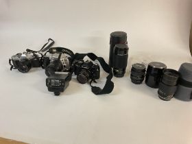 A collective lot of cameras and lenses including a Canon AV-1 camera. Postage C