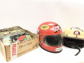 Two vintage motorcycle helmets and veteran car pla